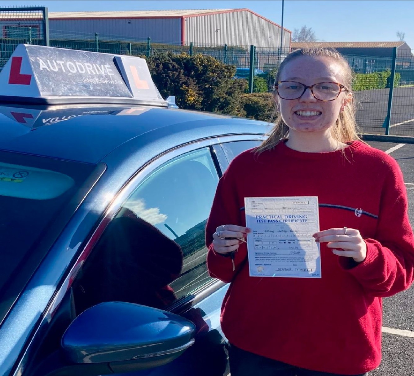 Bethany C. holding her practical driving test pass certificate