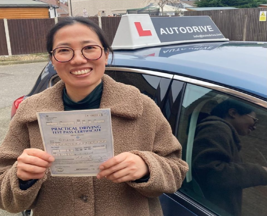 Bixiang S. holding her practical driving test pass certificate