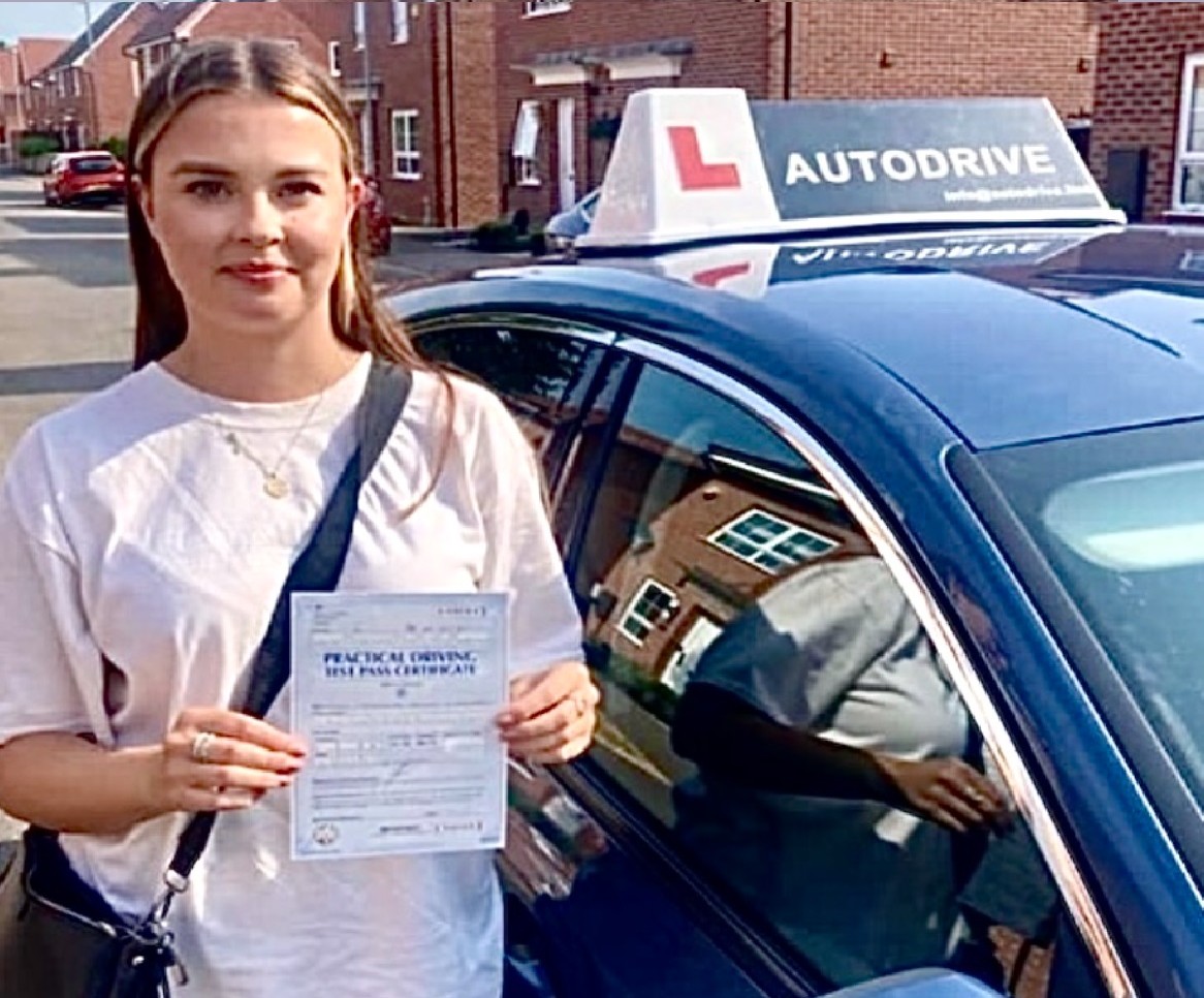 Catherine C. holding her practical driving test pass certificate