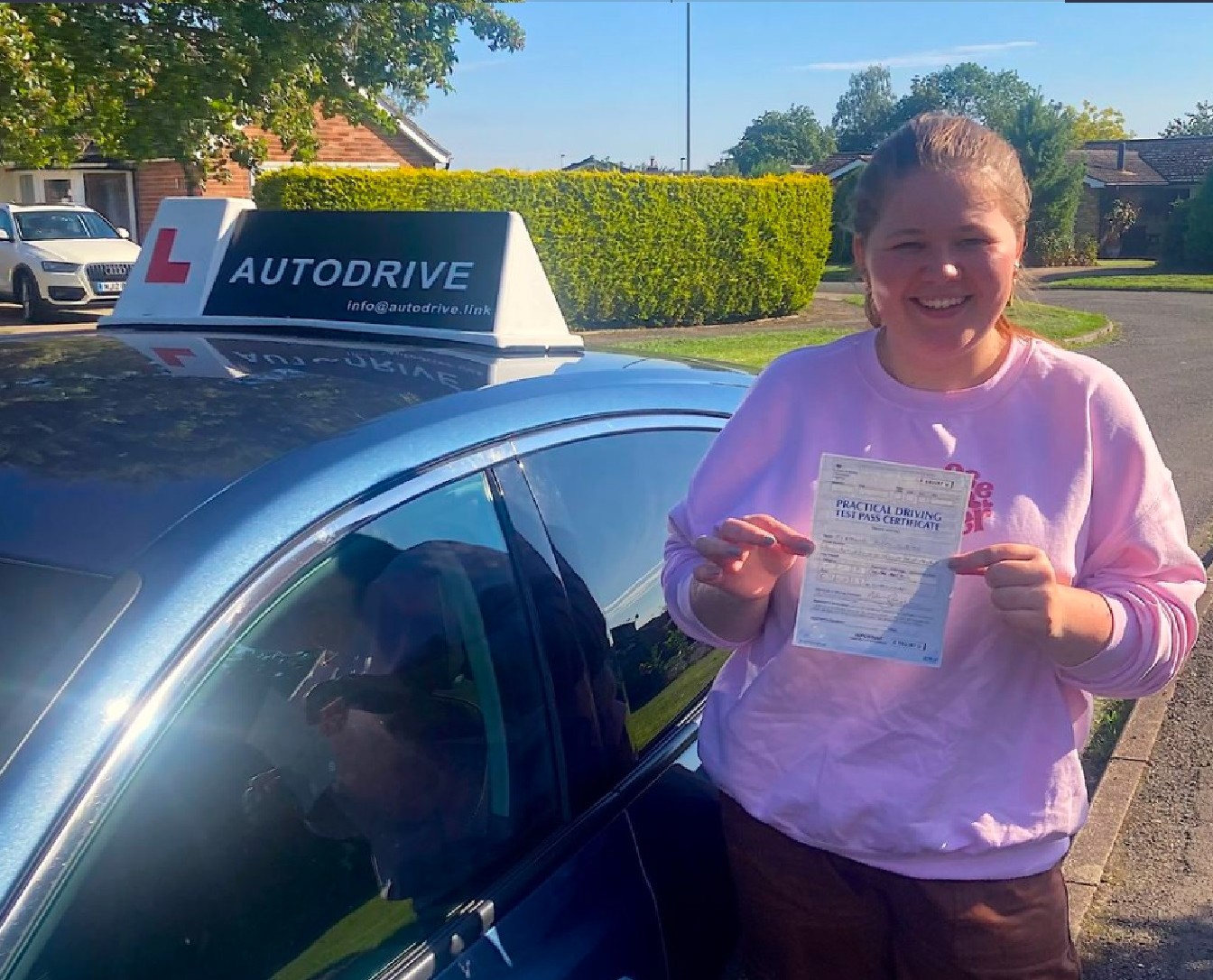 Eleanor P. holding her practical driving test pass certificate