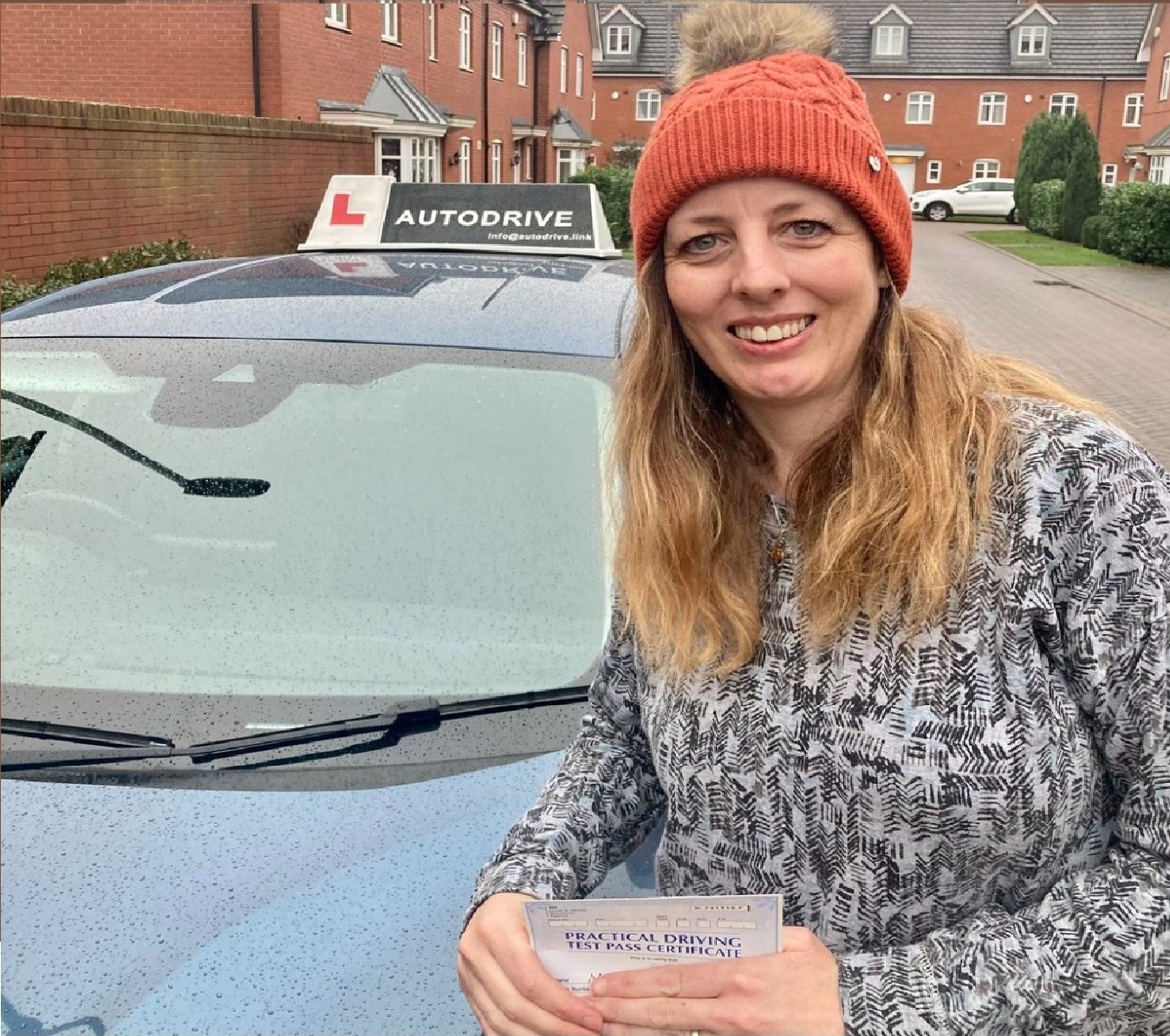 Michelle B. holding her practical driving test pass certificate