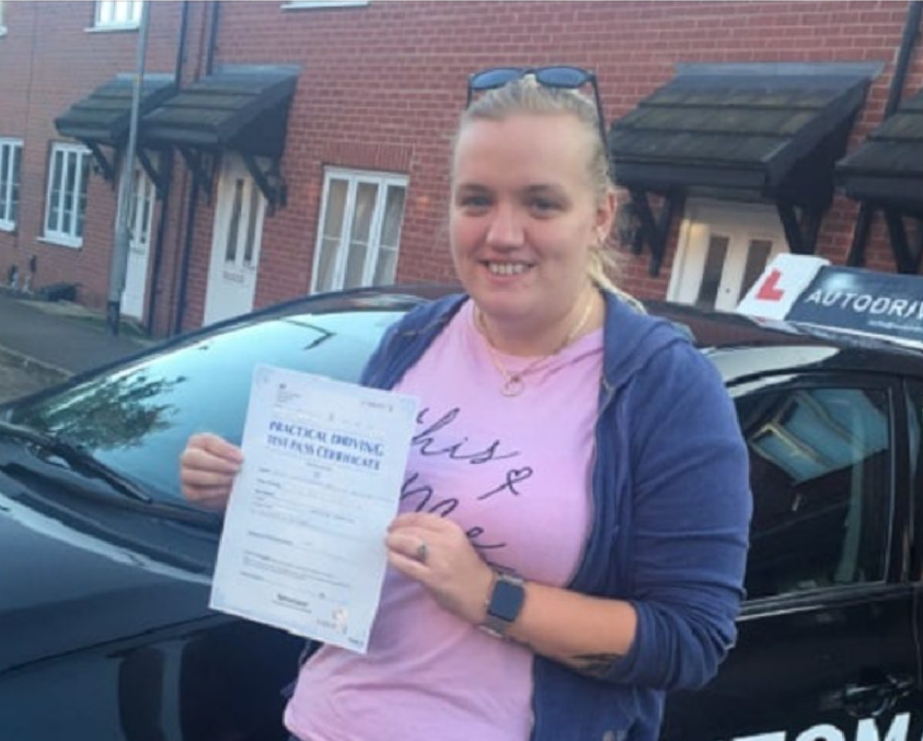 Sammy D. holding her practical driving test pass certificate